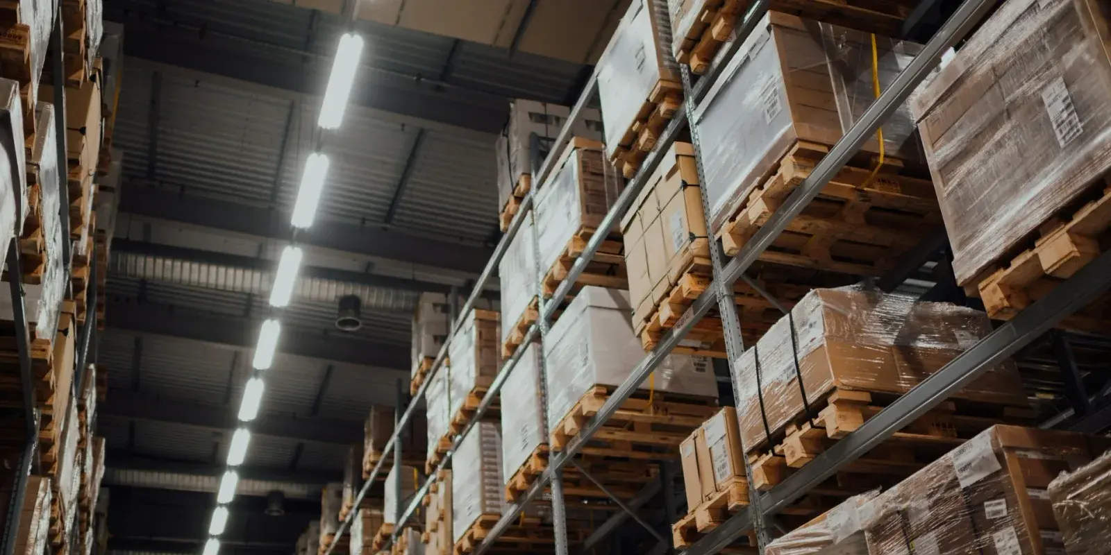 Tall warehouse pallet racking stacked with boxed inventory