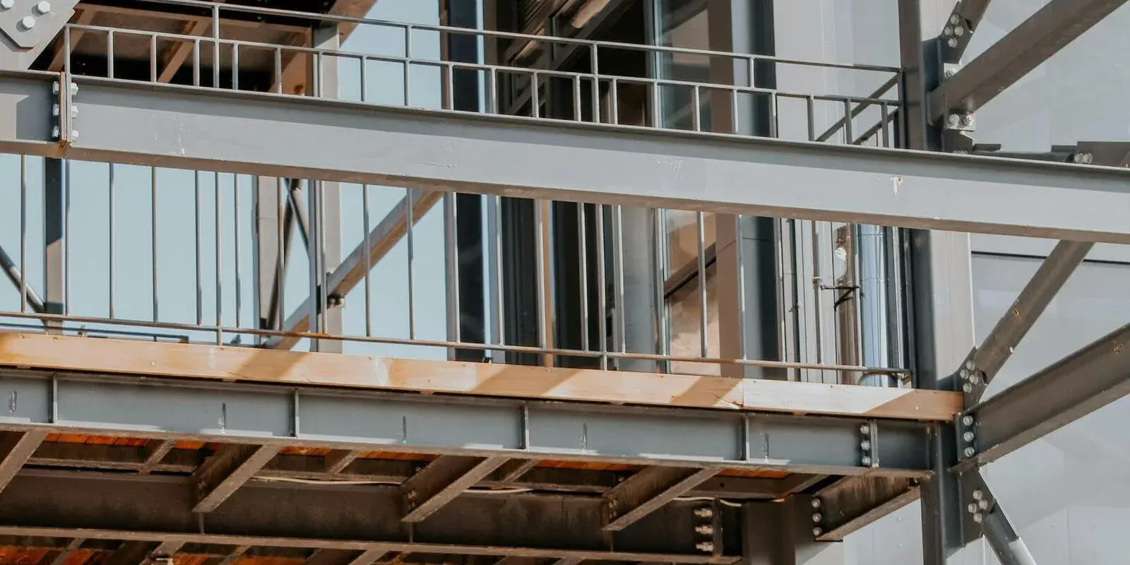 Structural steel beams and a mezzanine walkway with guardrails