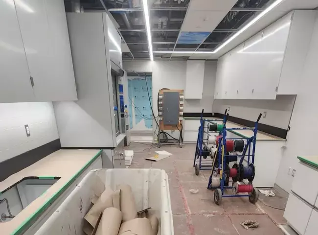 A newly built commercial kitchen mid-fit-out with cabinetry and electrical wiring spools