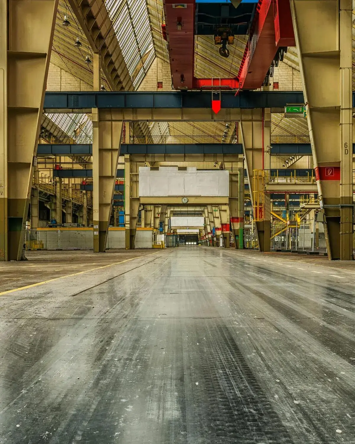 The interior of a large industrial warehouse with an overhead crane and a polished concrete floor