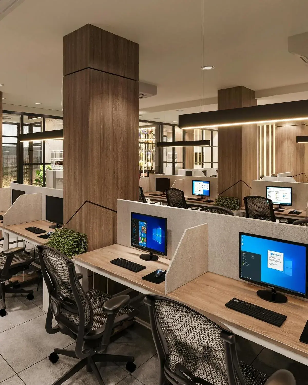 A modern open-plan office with rows of desks, monitors, and ergonomic chairs